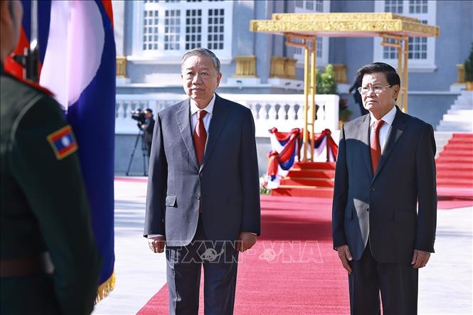 Tổng Bí thư Tô Lâm và Tổng Bí thư, Chủ tịch nước Lào Thongloun Sisoulith chào Quốc kỳ Lào, thực hiện nghi lễ duyệt Đội danh dự Quân đội nhân dân Lào. Ảnh: Dương Giang – TTXVN