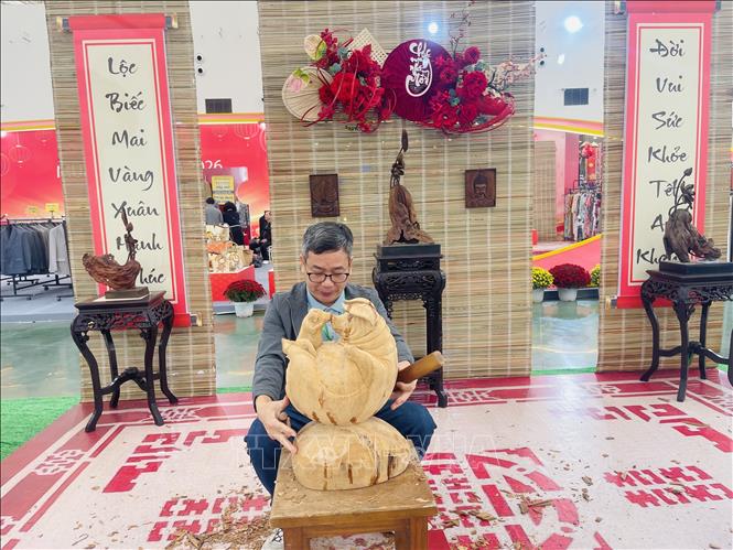 Nghệ nhân Phạm Văn Vững, Làng nghề chạm khắc gỗ mỹ nghệ Thiết Úng (Hà Nội), trình diễn chạm khắc gỗ mỹ nghệ truyền thống tại Hội chợ Mùa Xuân 2026. Ảnh: Tuyết Mai – TTXVN