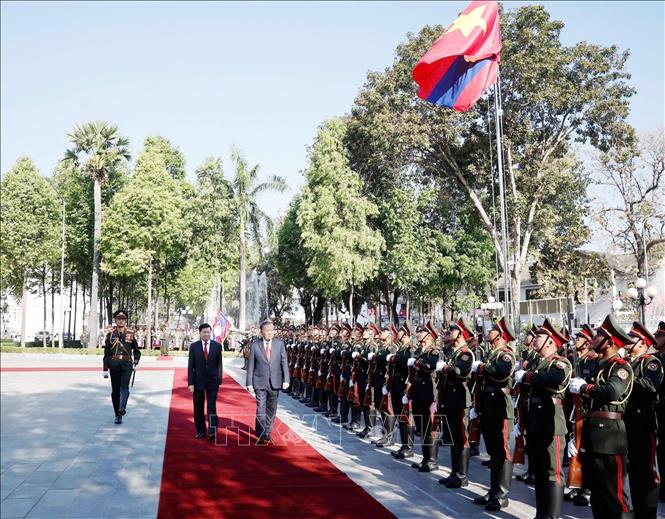 LPRP General Secretary and President Thongloun Sisoulith and Party General Secretary To Lam review the Guards of Honour of the Lao People's Army. VNA Photo