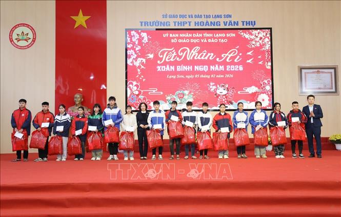 Các học sinh có hoàn cảnh khó khăn nhận quà trong Chương trình “Tết Nhân ái”. Ảnh: Anh Tuấn – TTXVN