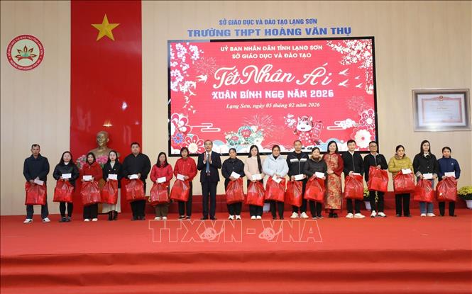 Các giáo viên/nhân viên có hoàn cảnh khó khăn nhận quà trong Chương trình “Tết Nhân ái”. Ảnh: Anh Tuấn – TTXVN 