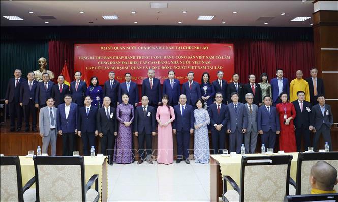 Tổng Bí thư Tô Lâm chụp ảnh lưu niệm với cán bộ Đại sứ quán và cộng đồng người Việt Nam tại Lào. Ảnh: Thống Nhất - TTXVN