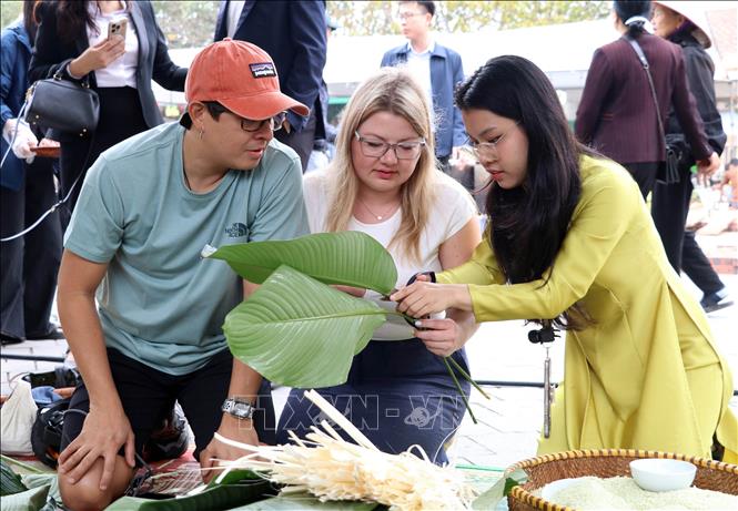 Người dân, du khách tham gia gói bánh chưng tại chương trình. Ảnh: Thùy Dung - TTXVN