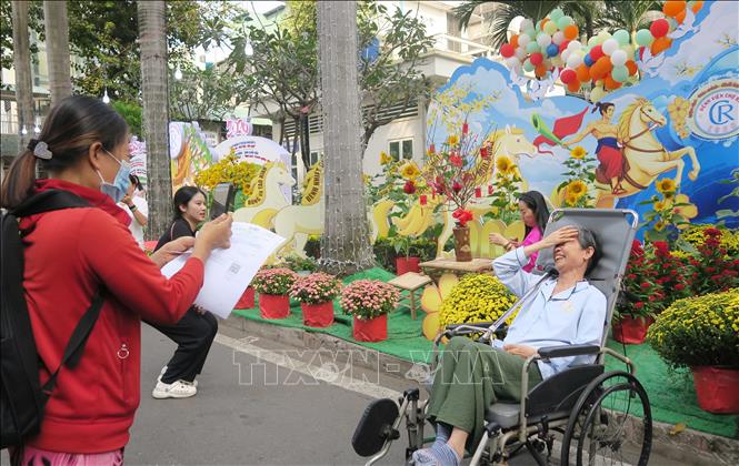 Người bệnh vui vẻ tạo dáng chụp ảnh tại đường hoa mừng xuân Bệnh viện Chợ Rẫy. Ảnh: Đinh Hằng - TTXVN