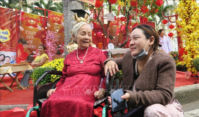 Người bệnh vui vẻ tạo dáng chụp ảnh tại đường hoa mừng xuân Bệnh viện Chợ Rẫy. Ảnh: Đinh Hằng - TTXVN