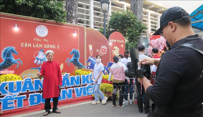 Một bệnh nhân được tình nguyện viên Phòng Công tác xã hội chụp ảnh kỷ niệm. Ảnh: Đinh Hằng - TTXVN