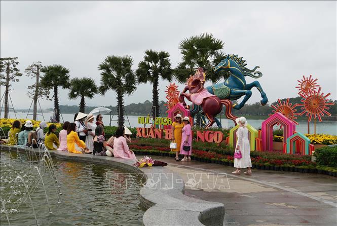 Du khách tham quan, chụp ảnh cùng linh vật ngựa đặt ở bờ Nam sông Hương, thành phố Huế. Ảnh: Nguyên Lý - TTXVN