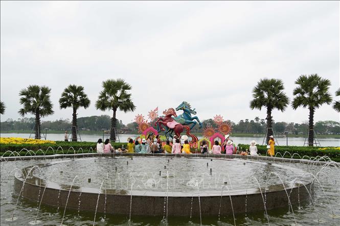 Du khách tham quan linh vật ngựa đặt ở bờ Nam sông Hương, thành phố Huế. Ảnh: Nguyên Lý - TTXVN