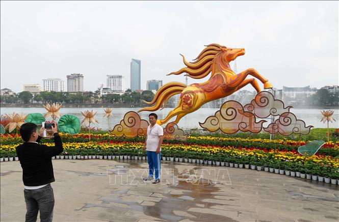 Du khách tham quan linh vật ngựa đặt ở bờ Bắc sông Hương, thành phố Huế. Ảnh: Nguyên Lý - TTXVN