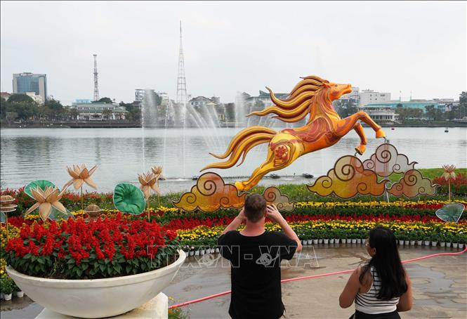 Du khách quốc tế tham quan linh vật ngựa đặt ở bờ Bắc sông Hương, thành phố Huế. Ảnh: Nguyên Lý - TTXVN
