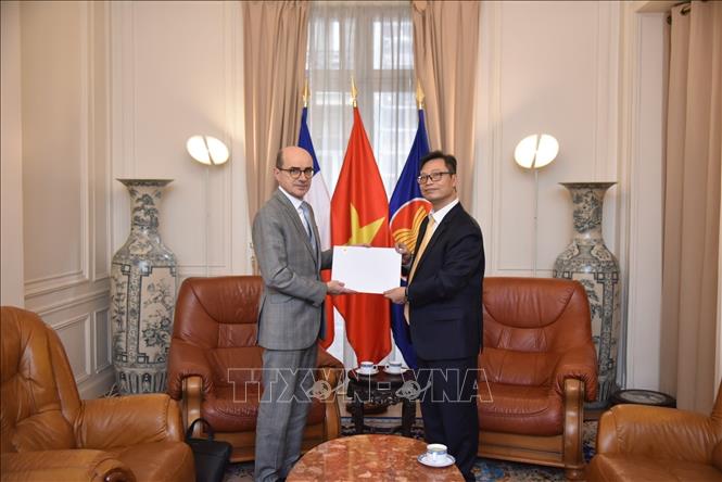 Đại sứ đặc mệnh toàn quyền Việt Nam tại Pháp Trịnh Đức Hải trao bản sao Quốc thư của Chủ tịch nước Lương Cường cho ông Mathieu Carmona, Phó Cục trưởng Cục Lễ tân, Bộ châu Âu và Ngoại giao Pháp. Ảnh: TTXVN phát