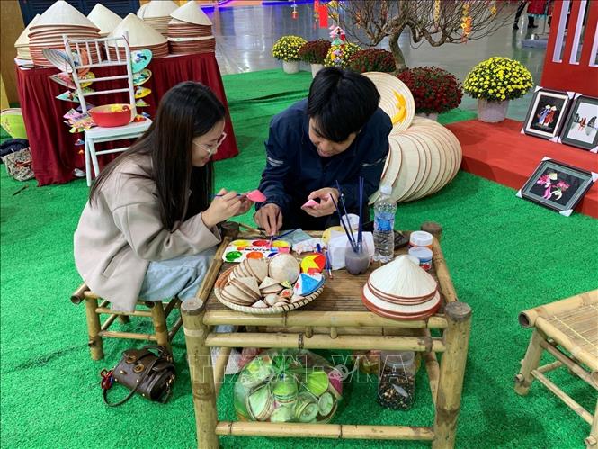 The display from Chuong conical hat village attracts throngs of visitors with its collection adorned in bright Tet-inspired patterns and festive colours. VNA Photo: Hạnh Quyên 