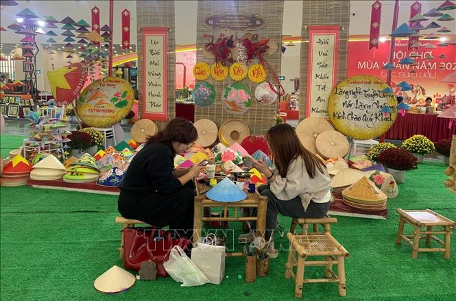 The display from Chuong conical hat village attracts throngs of visitors with its collection adorned in bright Tet-inspired patterns and festive colours. VNA Photo: Hạnh Quyên 