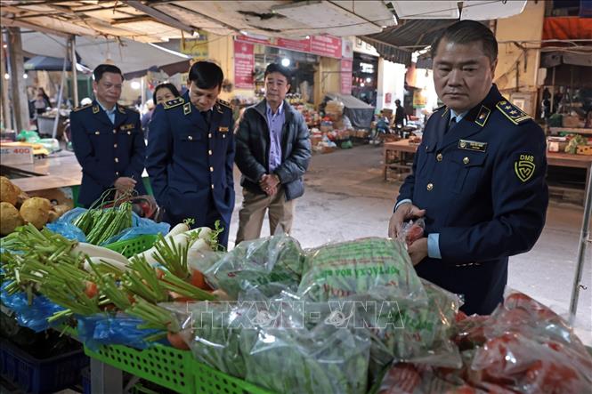 Lực lượng Quản lý thị trường Hà Nội kiểm tra quầy kinh doanh tại chợ Hà Đông. Ảnh: Trần Việt - TTXVN