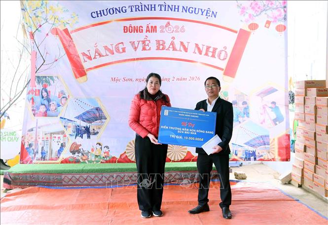 Đại diện gia đình Thanh Long (đồng hành cùng chương trình, bên phải) trao biểu trưng kinh phí hỗ trợ sửa chữa lớp học cho đại diện Trường Mầm non Đông Sang, phường Mộc Sơn, tỉnh Sơn La. Ảnh: Quang Quyết - TTXVN