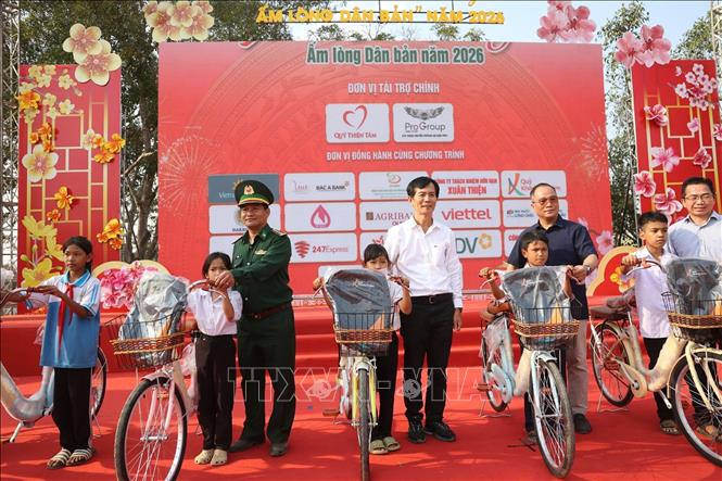 Trao tặng xe đạp, đồ dùng học tập cho học sinh có hoàn cảnh khó khăn. Ảnh: Tuấn Anh -TTXVN