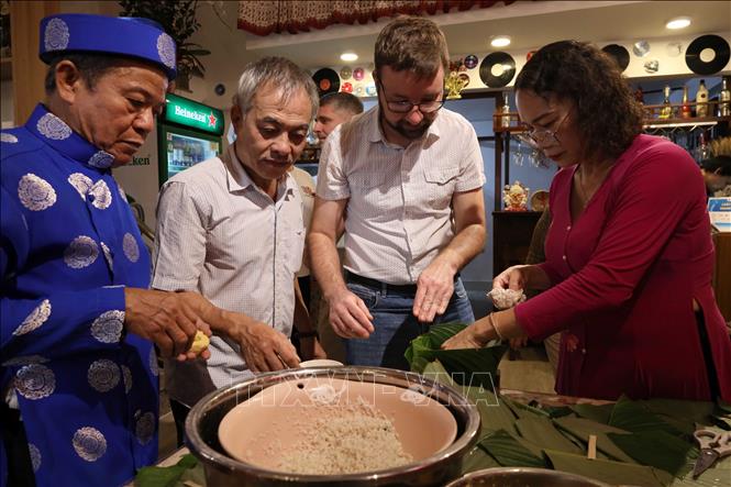 Vietnamese and Russian participants have hand-on experience of making banh Chung (a Vietnamese square-shaped sticky rice cake). VNA Photo: Trần Lê Lâm