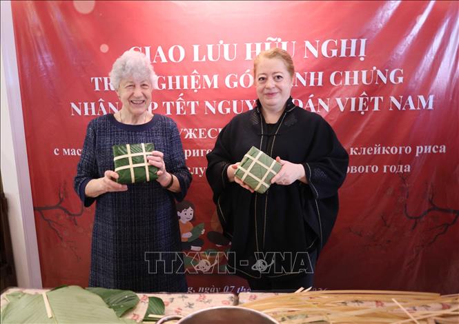 Russian participants have hands-on experience of making banh Chung (a Vietnamese square-shaped sticky rice cake). VNA Photo: Trần Lê Lâm