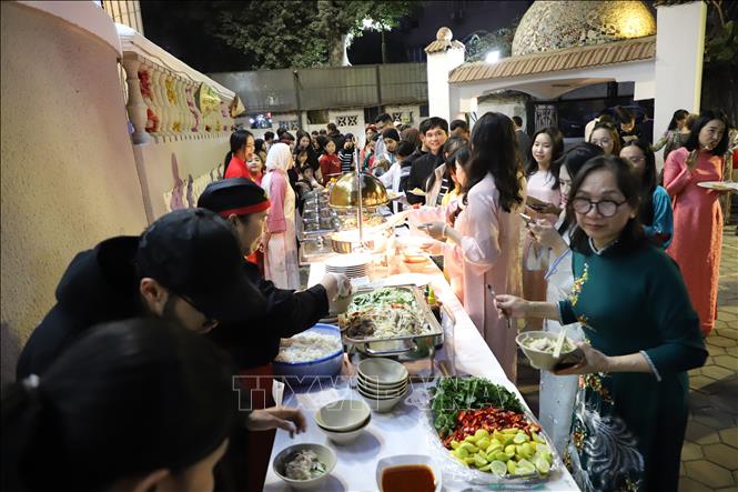 Bà con cộng đồng người Việt tại Ai Cập và bạn bè quốc tế thưởng thức các món ăn truyền thống của Việt Nam. Ảnh: Nguyễn Trường-TTXVN tại Ai Cập