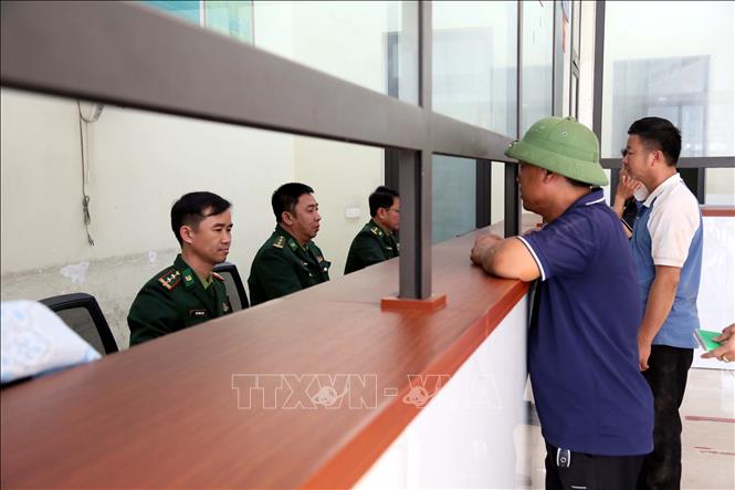 Cán bộ Trạm Biên phòng Cửa khẩu Quốc tế Cha Lo làm thủ tục nhập cảnh với các phương tiện. Ảnh: Tá Chuyên - TTXVN