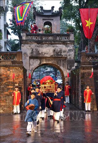 Trong không khí trang nghiêm và linh thiêng, hàng trăm người dân, nghệ sĩ, các thành viên cộng đồng văn hóa trong trang phục truyền thống tạo thành đoàn rước lễ tiến vào khu vực 36 phố phường, như một nghi thức loan báo tin mừng: mùa xuân mới đã trở về với Kinh kỳ. Ảnh: Thanh Tùng - TTXVN 