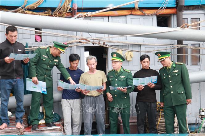 Lực lượng biên phòng tuyên truyền pháp luật khai thác thủy sản cho ngư dân. Ảnh: Tường Vi - TTXVN