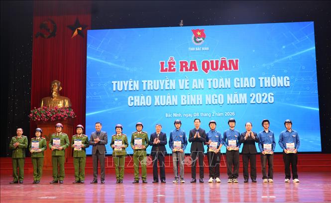 Ban tổ chức trao ấn phẩm và tặng mũ bảo hiểm cho đội hình tuyên truyền. Ảnh: Thanh Thương - TTXVN