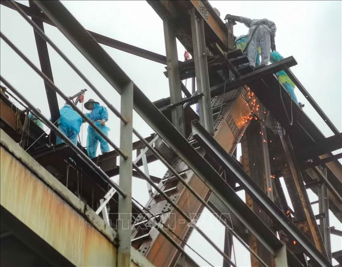 Hàng chục công nhân cùng nhiều thiết bị, vật liệu chuyên dụng tiếp tục vượt khó trong thời tiết mưa, rét của Hà Nội, khẩn trương triển khai sửa chữa, gia cố nhịp 18 cầu Long Biên. Ảnh: Thanh Tùng - TTXVN