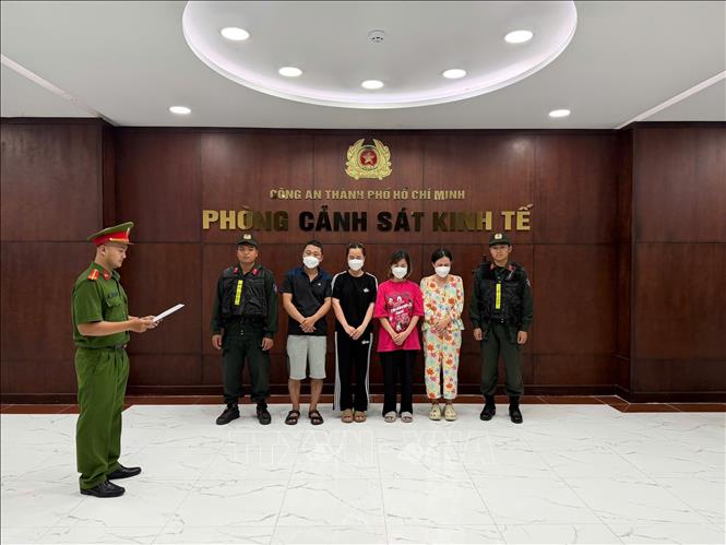 Cơ quan Cảnh sát điều tra tống đạt Quyết định khởi tố bị can đối với các đối tượng. Ảnh: TTXVN phát