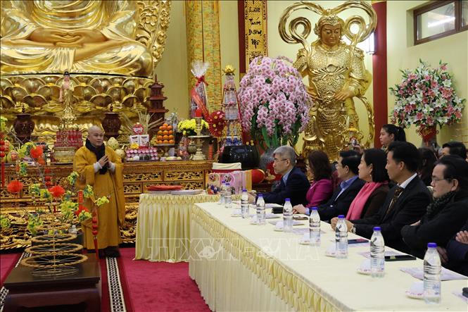 Thượng toạ Thích Thông Đạt chia sẻ với Đại sứ Nguyễn Đắc Thành cùng kiều bào về ý nghĩa của chiếc bánh chưng ngày Tết. Ảnh: Thu Hằng - Phóng viên TTXVN tại Đức