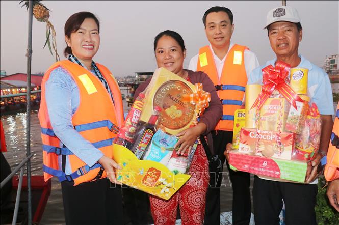 Đoàn công tác tặng quà Tết cho các tiểu thương chợ nổi Cái Răng. Ảnh: Ngọc Thiện- TTXVN