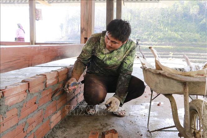 Anh Thào Thành Sinh, thôn Làng Sang, xã Púng Luông phấn khởi cố gắng hoàn thiện ngôi nhà trước ngày 25/12 âm lịch để vợ con sắm Tết. Ảnh: Tuấn Anh - TTXVN