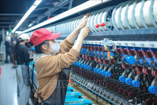 Công nhân làm việc trên dây chuyền ươm tơ hiện đại của nhà máy Công ty Cổ phần Dâu tằm tơ Yên Bái. Ảnh: Hoàng Hiếu - TTXVN