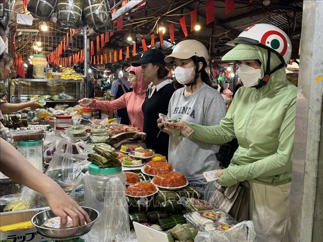 Người dân mua sắm đồ cúng Ông Công, Ông Táo tại chợ Nhân Chính, phường Thanh Xuân, thành phố Hà Nội. Ảnh: Quốc Lũy - TTXVN