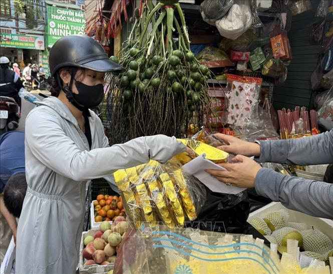 Người dân mua sắm đồ cúng Ông Công, Ông Táo tại chợ Nhân Chính, phường Thanh Xuân, thành phố Hà Nội. Ảnh: Quốc Lũy - TTXVN 