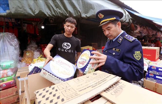 Lực lượng Quản lý thị trường kiểm tra hàng hóa ở chợ Hà Tĩnh. Ảnh: Công Tường-TTXVN