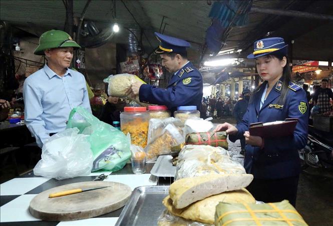 Lực lượng Quản lý thị trường kiểm tra an toàn thực phẩm. Ảnh: Công Tường-TTXVN