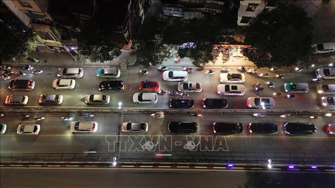 Các phương tiện nối đuôi nhau nhích từng mét một trên phố Tây Sơn tối ngày 9/2. Ảnh: Quốc Khánh - TTXVN