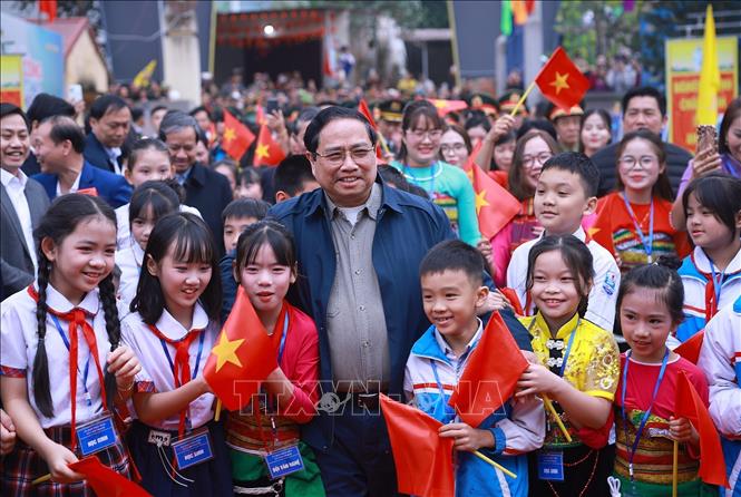 Thủ tướng Phạm Minh Chính với học sinh tham dự Lễ khởi công dự án Trường liên cấp Cẩm Thạch. Ảnh: Dương Giang-TTXVN
