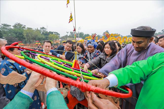 Các đại biểu treo khánh lên cây nêu cầu chúc năm mới bình an, nhiều may mắn. Ảnh: Khánh Hoà - TTXVN