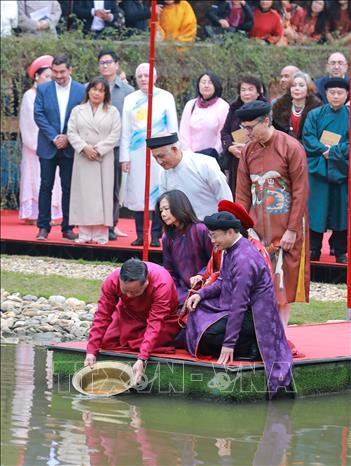 Các đại biểu thực hiện Lễ thả cá Chép tiễn ông Công ông Táo về trời. Ảnh: Khánh Hoà - TTXVN