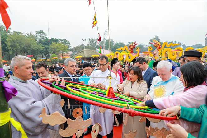 Các đại biểu treo khánh lên cây nêu cầu chúc năm mới bình an, may mắn. Ảnh: Khánh Hoà - TTXVN