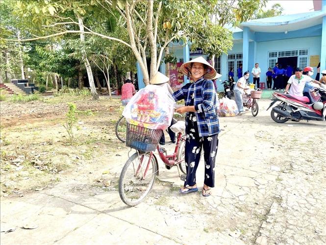 Bà Văn Thị Thông, ngụ ấp Đắc Thắng, xã Hồ Đắc Kiện, thân nhân đang thờ cúng liệt sĩ Nguyễn Văn Tửng, vui mừng nhận quà Tết trong chương trình “Xuân tri ân – Tết nghĩa tình” năm 2026. Ảnh: TTXVN phát