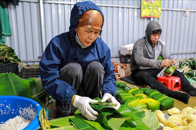 Đôi tay người thợ thoăn thoắt gói bánh, từng nếp gấp vuông vắn cho thấy sự thuần thục được tích lũy qua nhiều năm gắn bó với nghề. Ảnh: Khánh Hoà - TTXVN