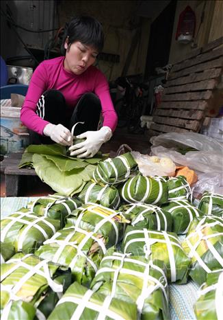  Đôi tay người thợ thoăn thoắt gói bánh, từng nếp gấp vuông vắn cho thấy sự thuần thục được tích lũy qua nhiều năm gắn bó với nghề. Ảnh: Khánh Hoà - TTXVN                      