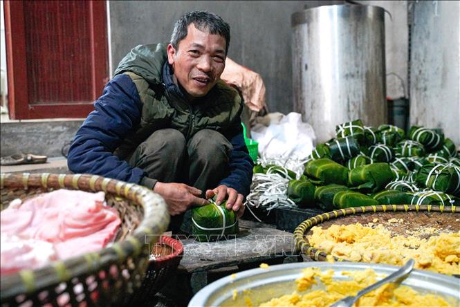 Đôi tay người thợ thoăn thoắt gói bánh, từng nếp gấp vuông vắn cho thấy sự thuần thục được tích lũy qua nhiều năm gắn bó với nghề. Ảnh: Khánh Hoà - TTXVN