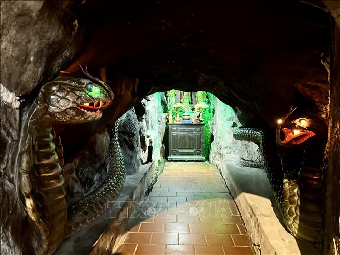 Dọc hai bên lối đi vào trong hang đá là hai tượng linh vật rắn gắn với truyền thuyết của ngôi chùa. Ảnh: Thanh Sang - TTXVN