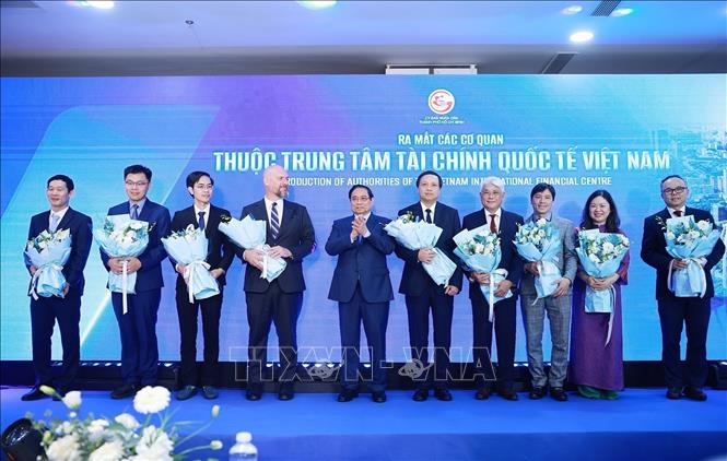 Prime Minister Pham Minh Chinh presents flowers to representatives of units under the Vietnam International Financial Centre. VNA Photo: Dương Giang