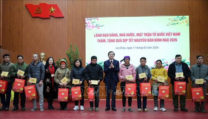 Đồng chí Đoàn Minh Huấn tặng quà cho các hộ dân có hoàn cảnh khó khăn tại phường Tân Phong. Ảnh: Nguyên Oanh-TTXVN.