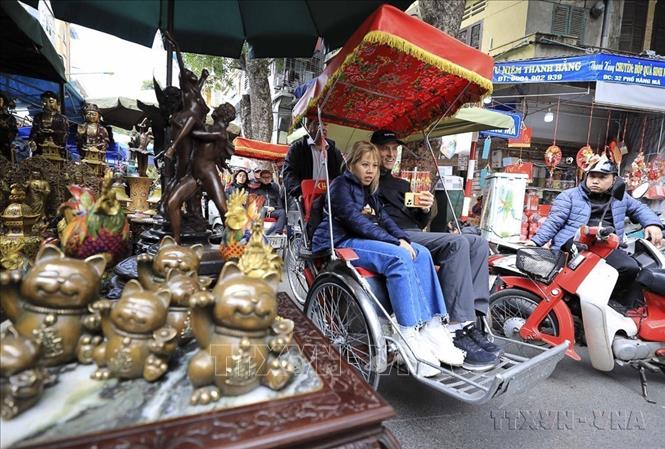 Du khách thích thú với cung đường tham quan qua chợ hoa Hàng Lược (2023). Ảnh: Nhật Anh - TTXVN